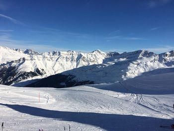 Scenic view of snowcapped mountains against blue sky