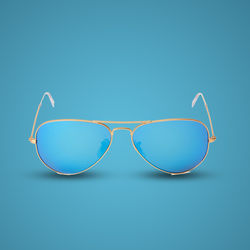 Close-up of sunglasses against blue sky