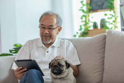 Man using mobile phone while sitting on sofa