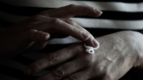 Cropped hand of woman applying moisturizer