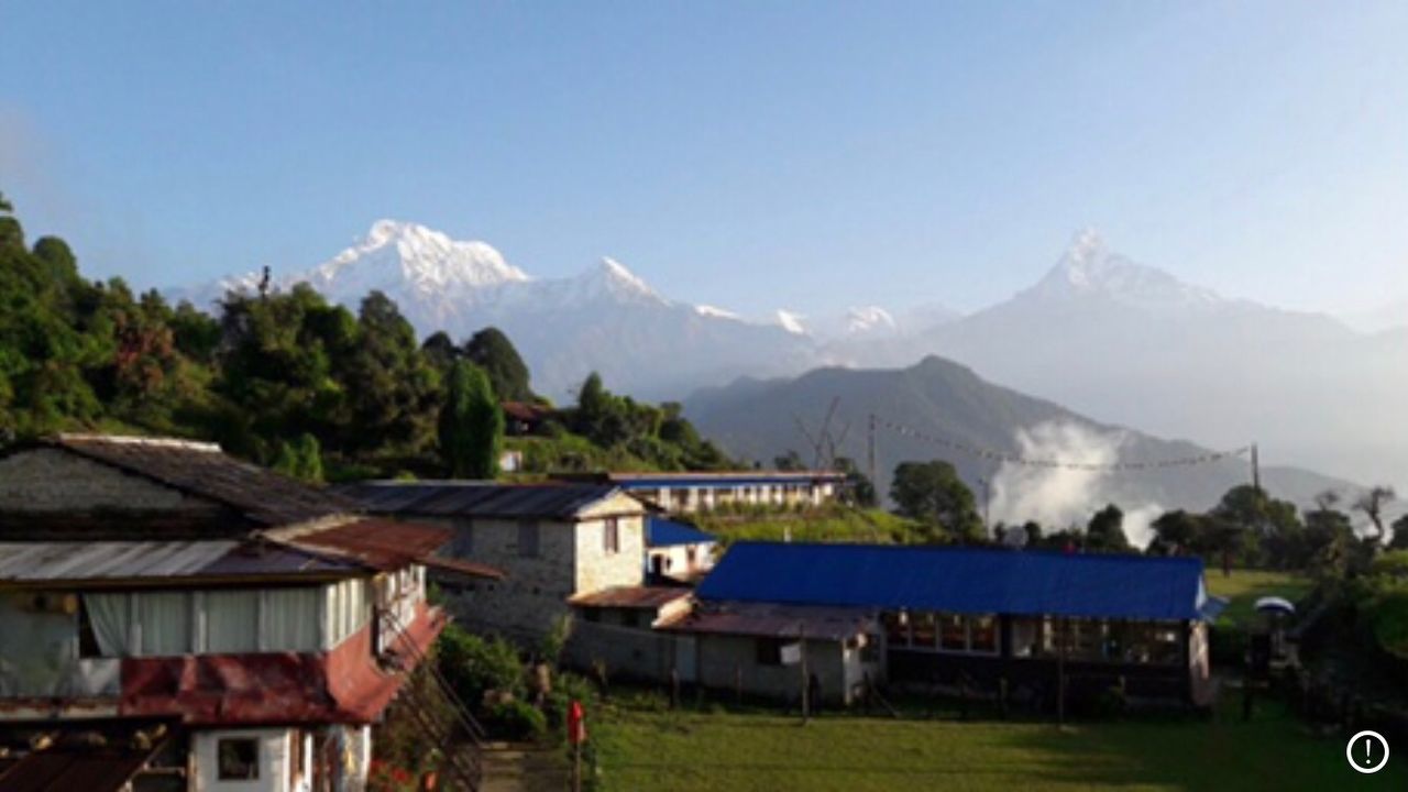 HOUSES AGAINST MOUNTAINS AND SKY