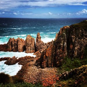 Rock formations by sea against sky