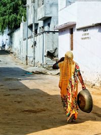 Indian woman in colourful dress walking through a street