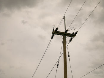 Low angle view of electricity pylon against sky