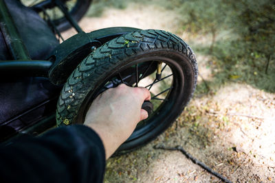 Close-up of man touching tire of baby stroller