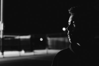 Portrait of young man looking away at night