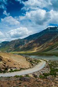 Scenic view of road by mountain against sky