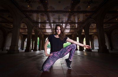 Portrait of woman sitting on floor in building