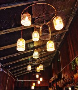 Low angle view of illuminated pendant lights hanging from ceiling