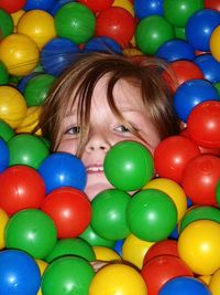 Portrait of girl amidst multi colored balls