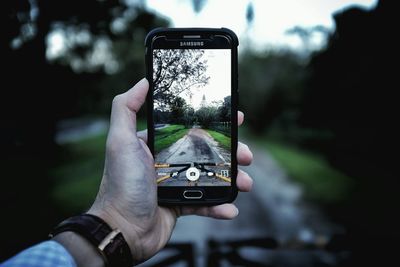 Close-up of hand holding mobile phone in city