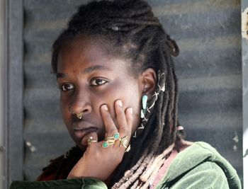 Close-up of woman with hand on cheek looking away