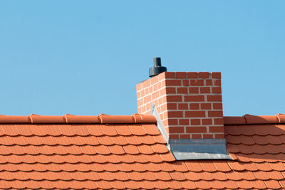 Roof with red roof tiles and chimney