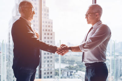 Midsection of man standing with arms raised in city
