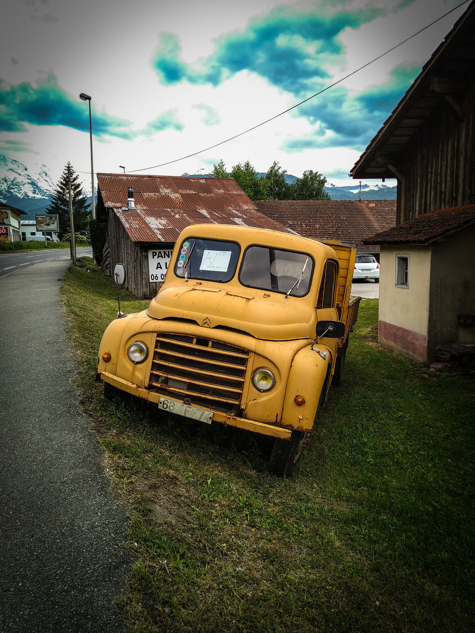 VINTAGE CAR ON ROAD AGAINST SKY