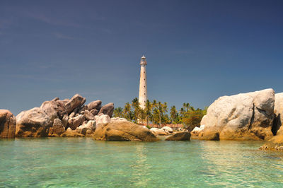 Rock formation by sea against sky