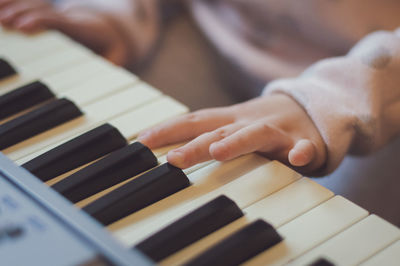 A little girl plays the electric piano.