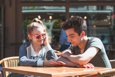 Portrait of cute girl and son on table