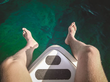 Low section of man legs in swimming pool