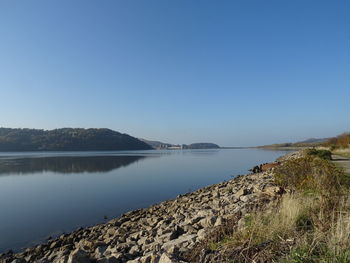 Scenic view of lake against clear blue sky