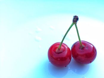 Close-up of cherries on table against blue background