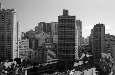 Aerial view of buildings in city against clear sky