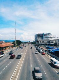 Cars on road in city against sky