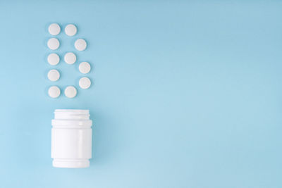 Close-up of white bottle against blue background