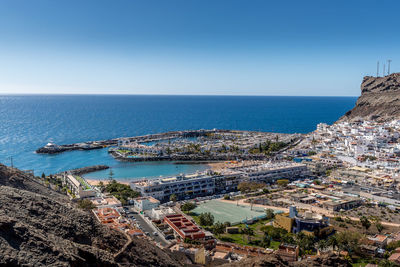 High angle view of townscape by sea against clear sky