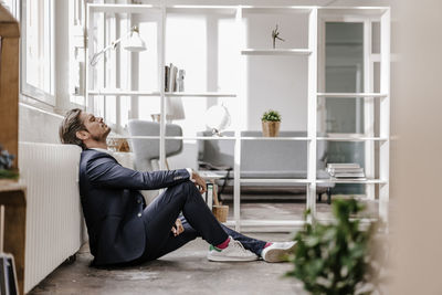 Exhausted businessman sitting on the floor