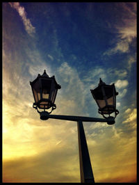 Low angle view of street light against cloudy sky