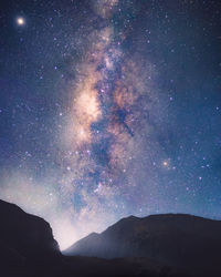 Scenic view of silhouette mountains against sky at night