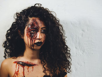 Close-up of young woman with spooky face paint