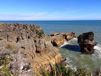 Scenic view of rocks geological rocks formations in sea against sky