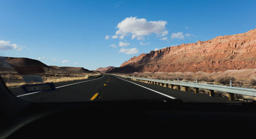 Road against sky seen through car windshield