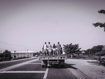 People on road against sky in city