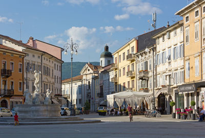 People on street amidst buildings in city