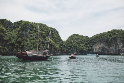 Fishing boat on halong bay by mountains