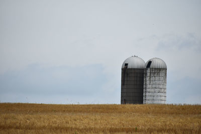 Silo on field against sky