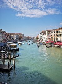 Boats moored at harbor against buildings in city