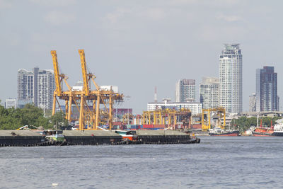 View of buildings by sea against sky