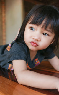 Portrait of smiling girl sitting on table at home