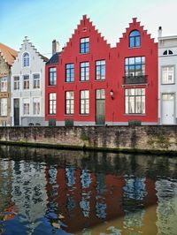 Reflection of building in canal against sky