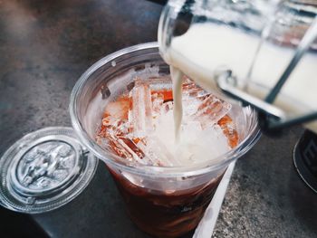 Close-up of milk pouring in jar on table