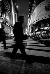 Woman walking on city street at night