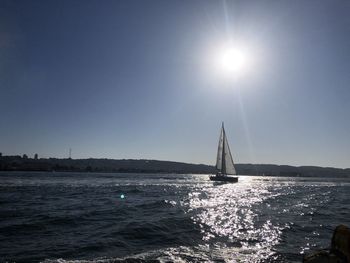 Sailboat sailing on sea against clear sky