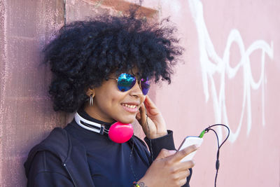 Portrait of smiling woman against wall