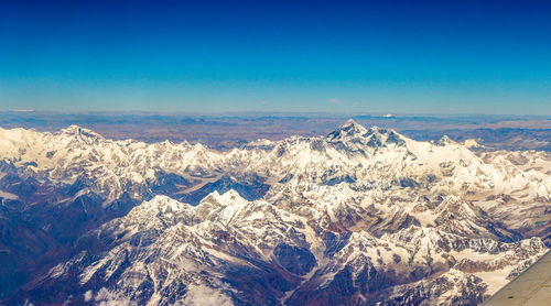 Scenic view of snowcapped mountains against clear blue sky