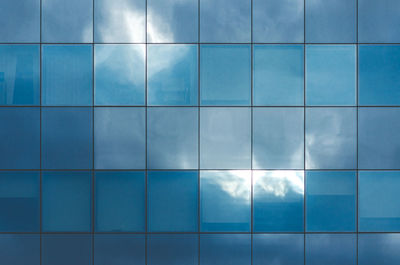 Irregular clouds and sky reflections on textured blue glass