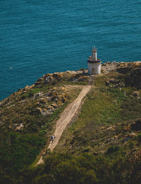 High angle view of lighthouse amidst sea and buildings